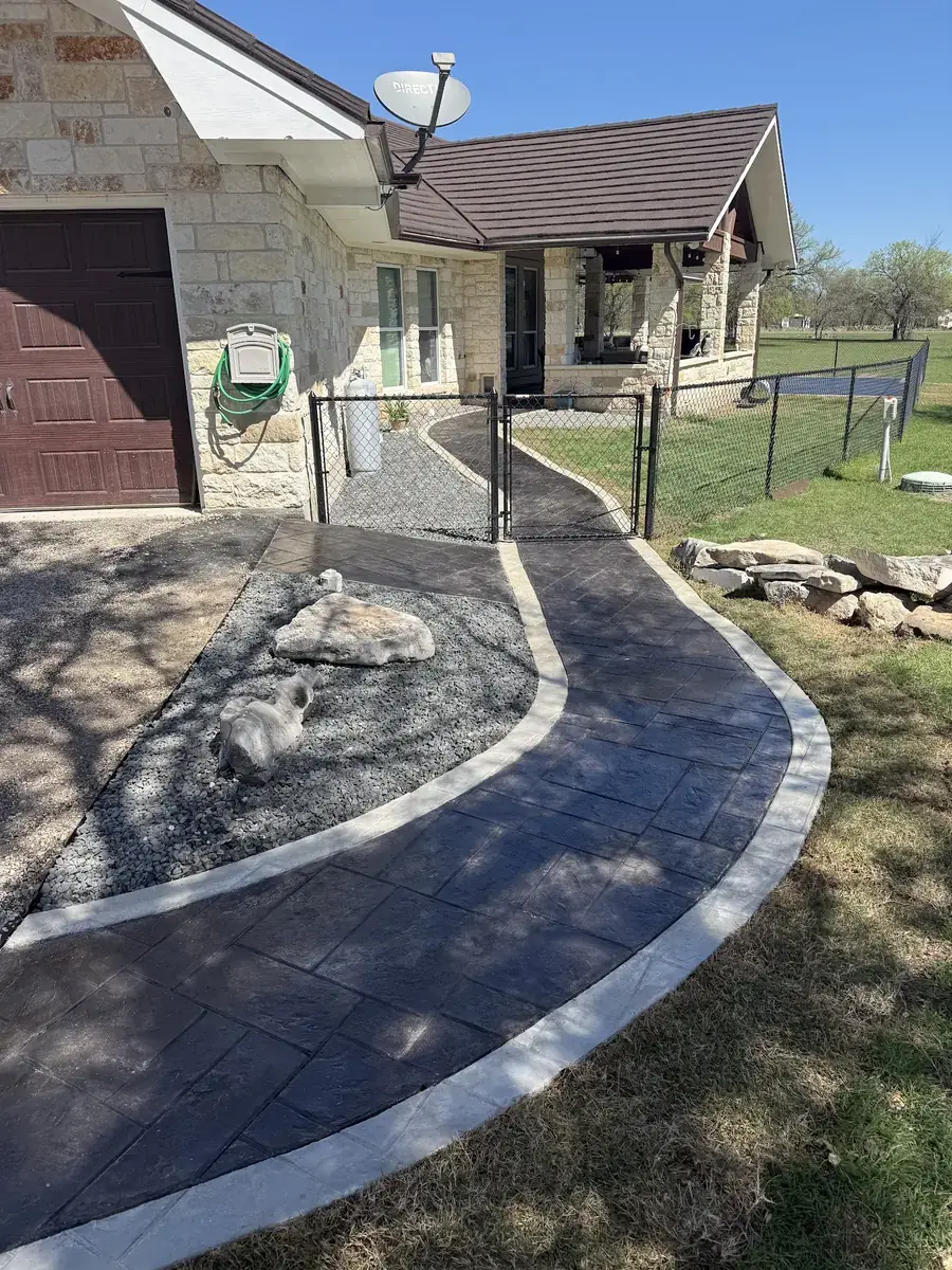 Stamped concrete walkway curving to a gate in Temple, Texas